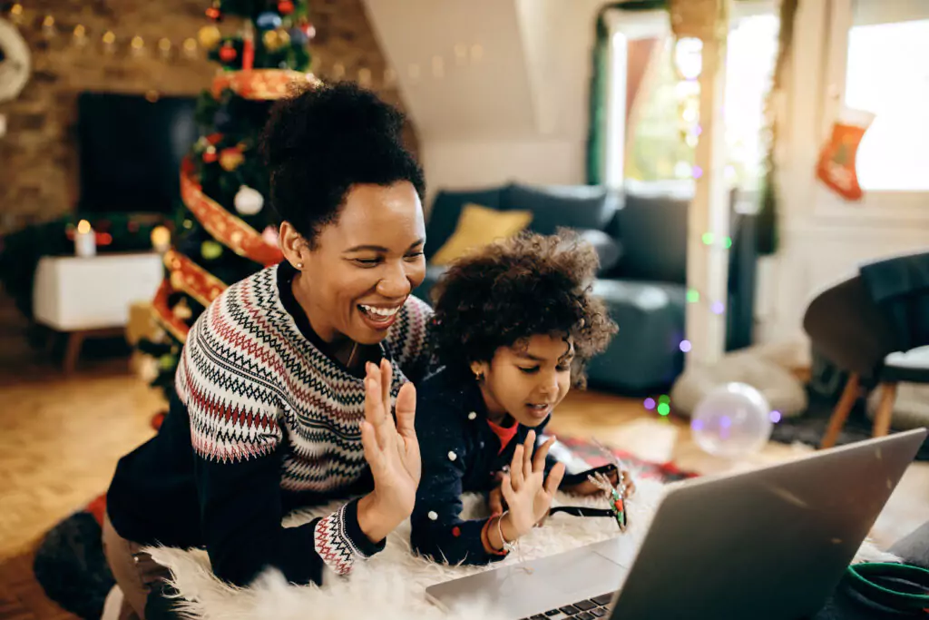 woman and child waving at a laptop Christmas