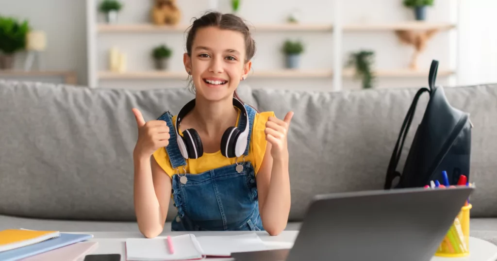 girl with headphones and a backpack smiling and giving two thumbs up