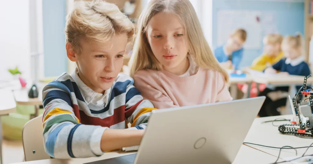 two children using a laptop
