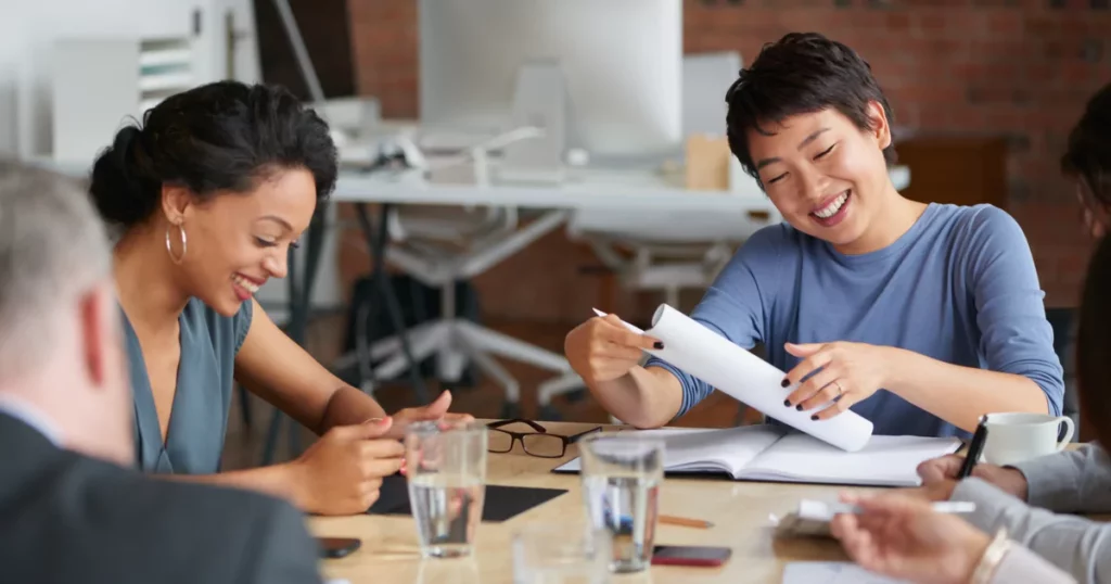 team members discussing something at a large desk