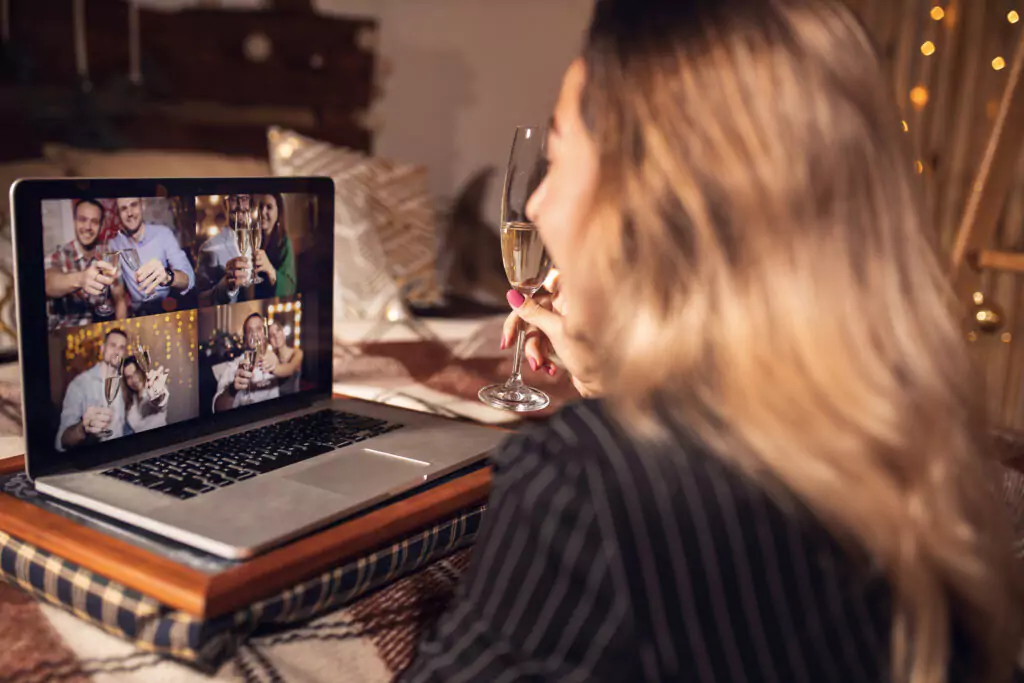 woman with champagne glass on a Zoom call