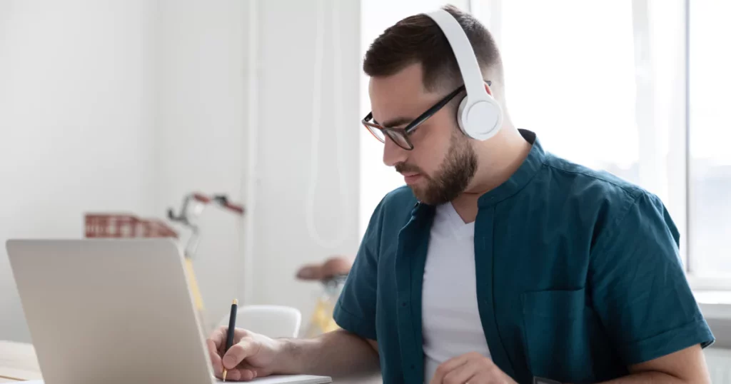 man-beard-glasses-pen-white-headphones