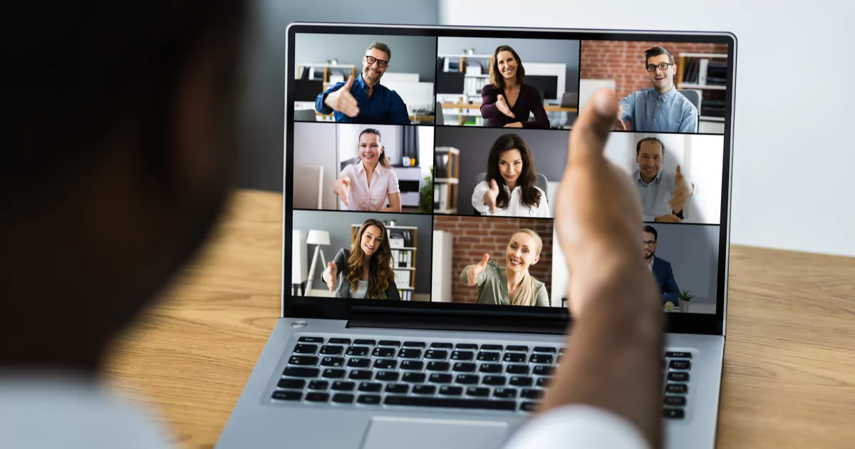 man shaking hands with zoom call coworkers