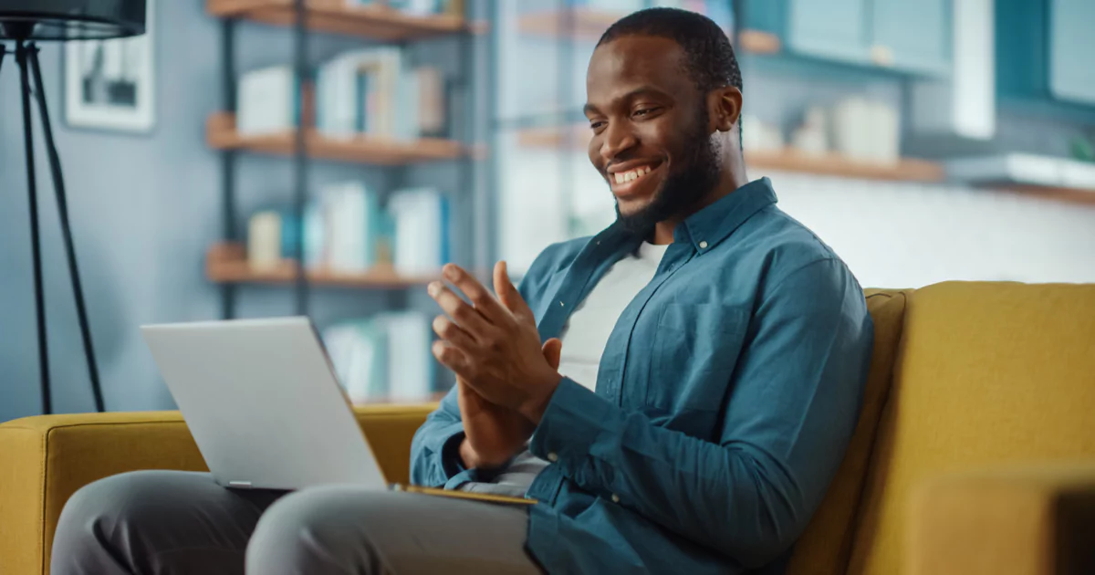 man smiling and clapping on a call