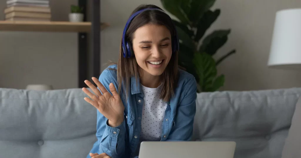 woman-headphones-blue-shirt-waving-laptop