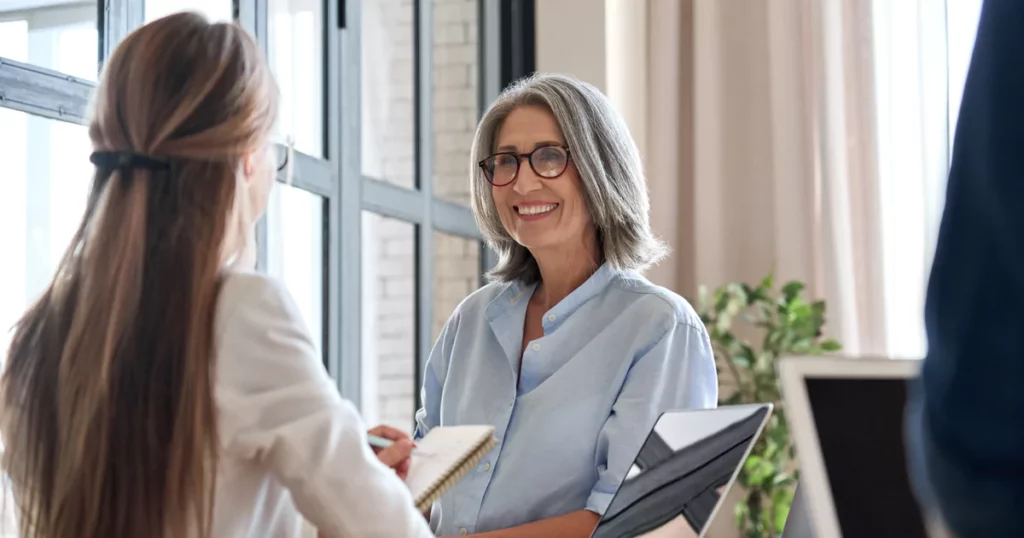 smiling-elder-woman-glasses-button-up-office