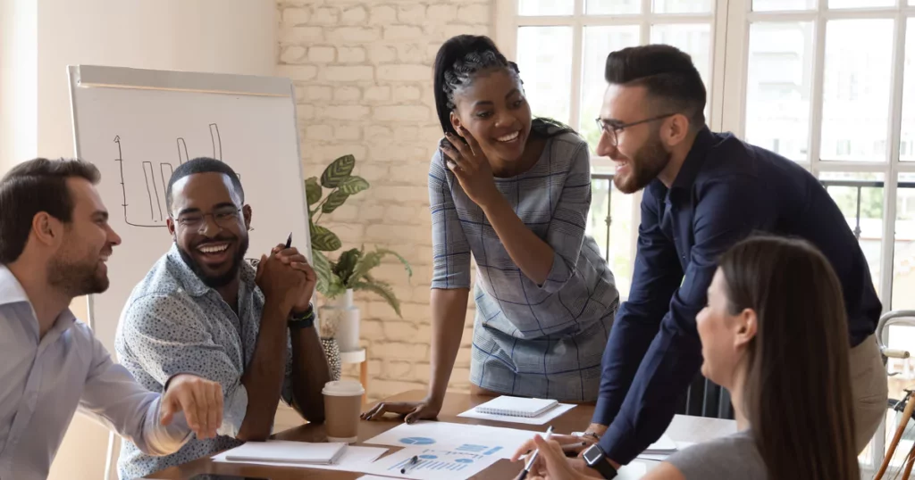 teammates-meeting-smiling-office-table