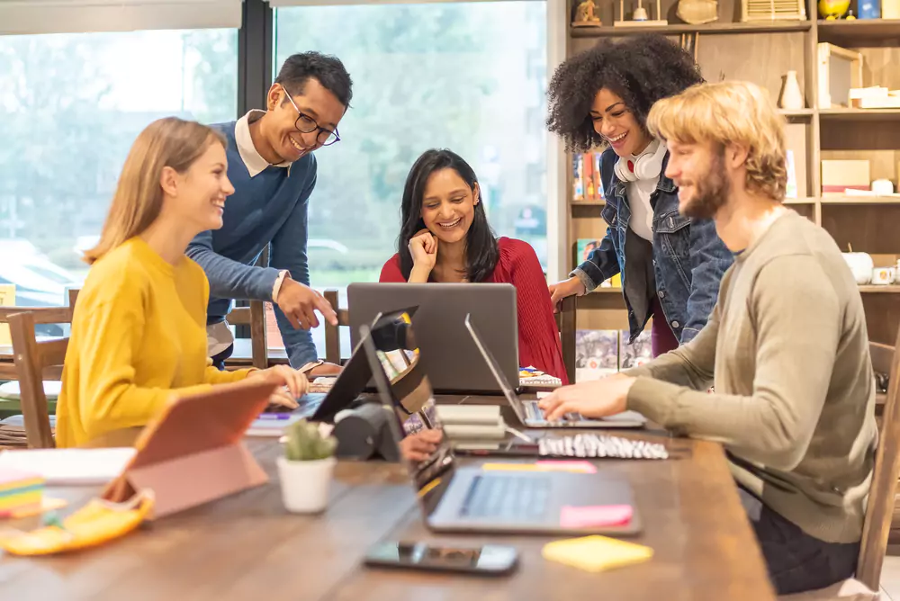 employees chatting around laptops