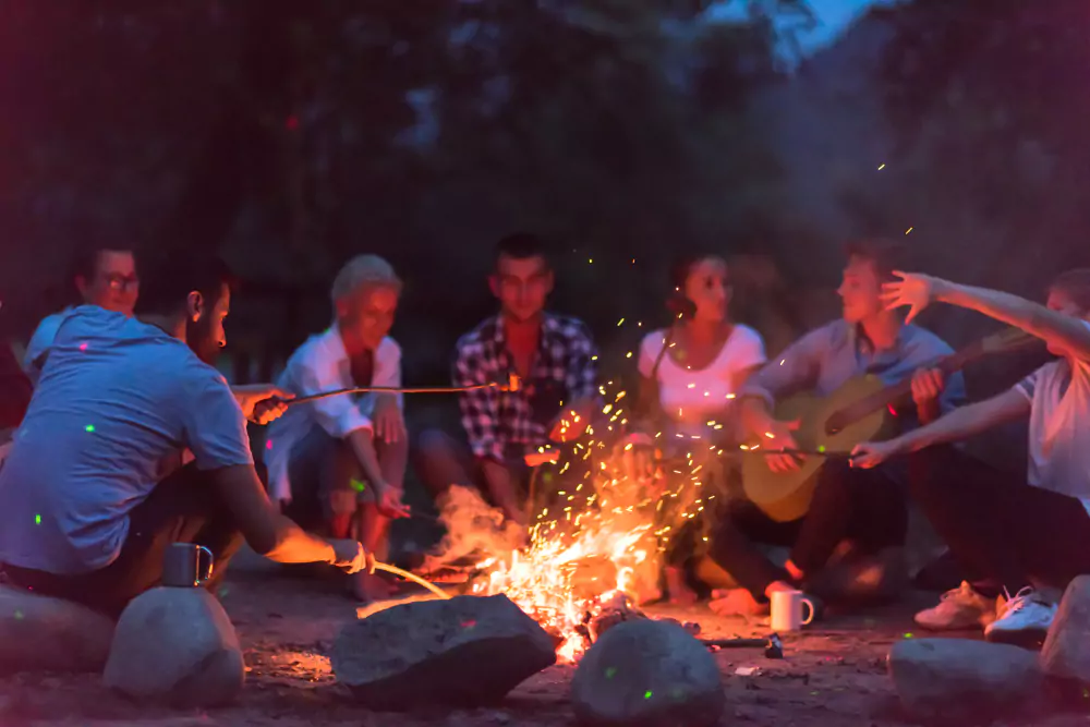 employees sitting around a campfire