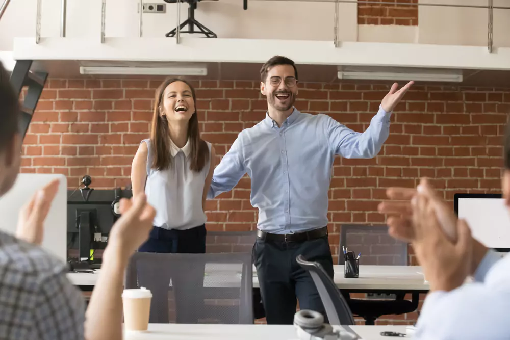 boss celebrating employee in front of others