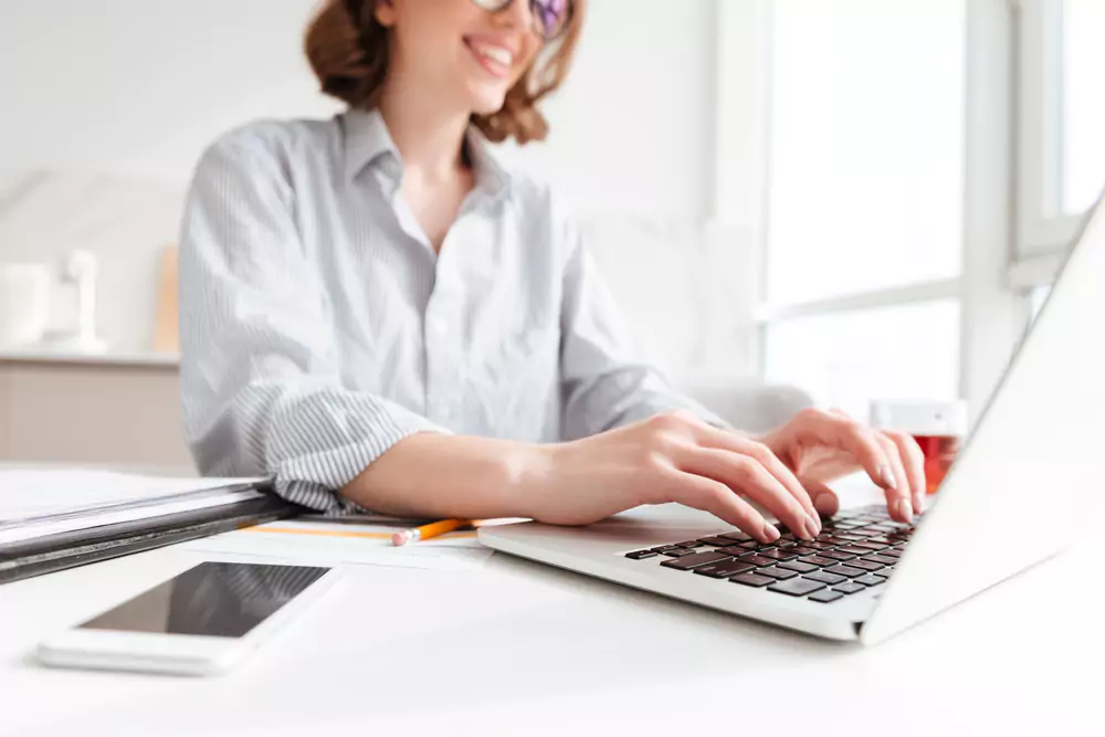 employee typing on laptop