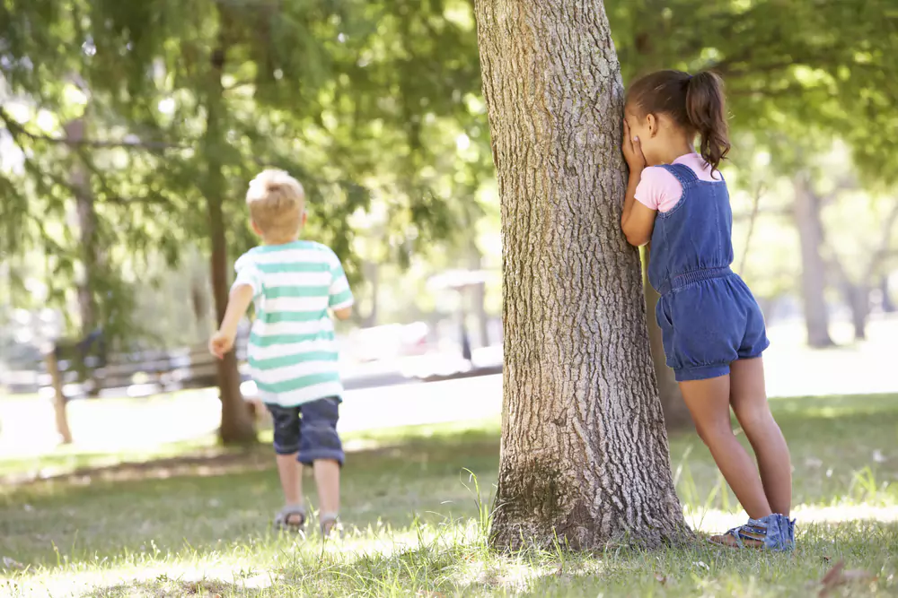 kids playing hide and seek in woods