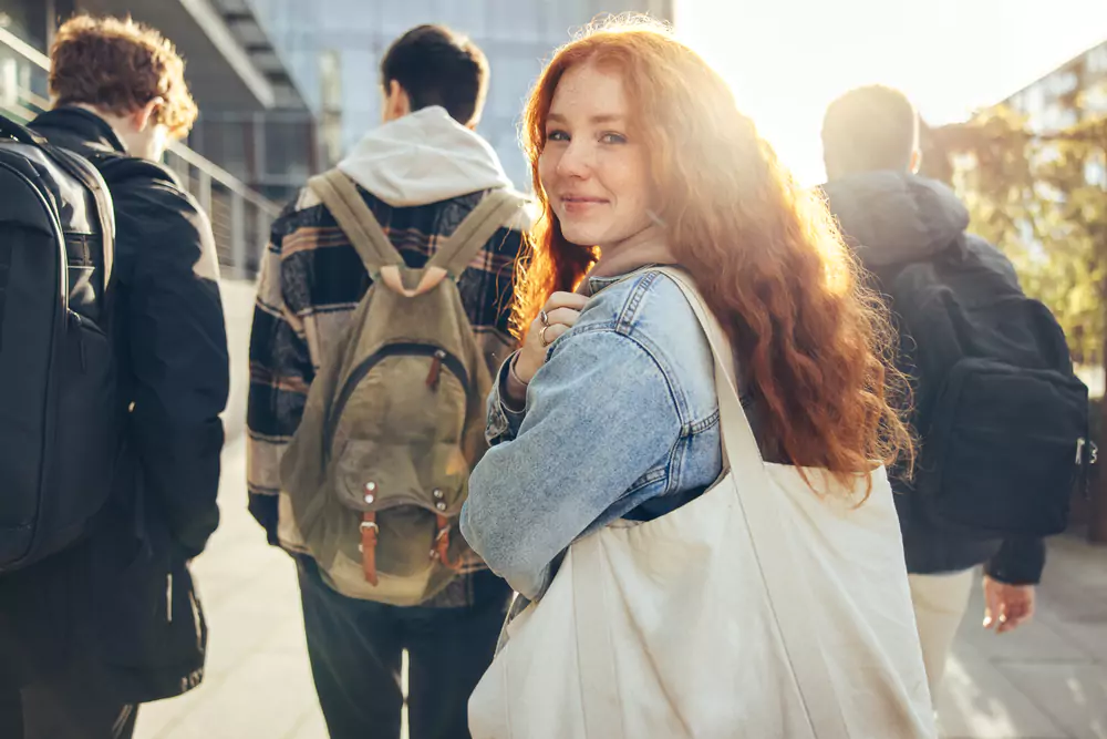 teenagers walking through the city looking back at camera